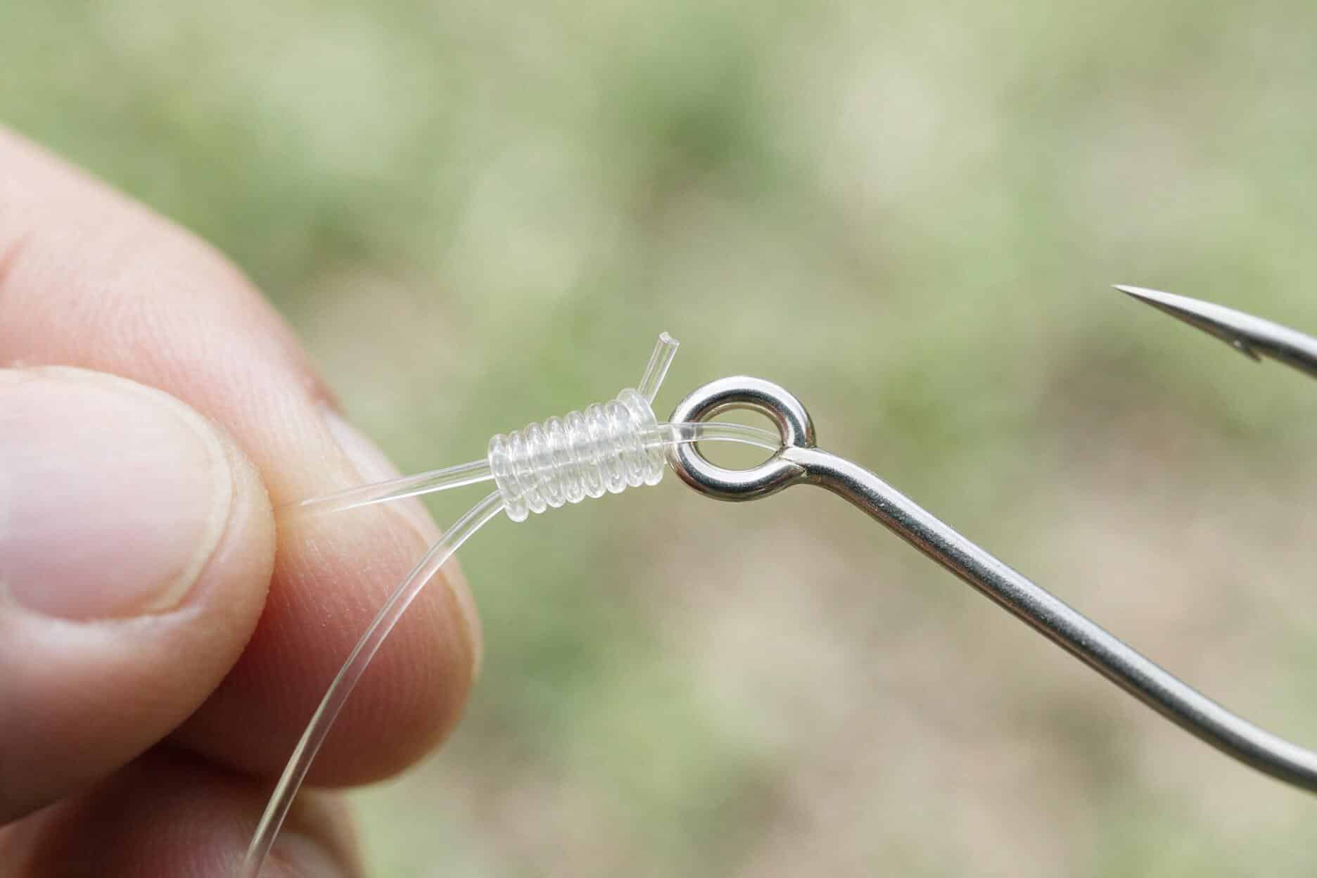 Improved clinch knot tied onto a fishing hook eye showing the coil wraps and tag end